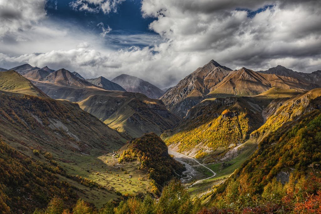 Captivating autumn mountain landscape in Gudauri, showcasing vibrant fall colors and rugged peaks.